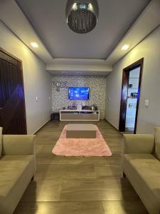 a living room with two couches and a flat screen tv at Casa de Praia in Imbituba