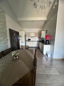 a dining room with a table and a kitchen at Casa de Praia in Imbituba