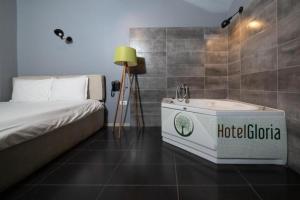 Habitación con cama y bañera. en Hotel Gloria KS, en Pristina