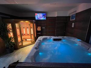 Una gran bañera azul en una habitación con TV en Sweet Home Apartman en Balatonszárszó
