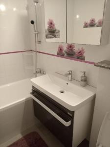 a white bathroom with a sink and a shower at Penti Apartament in Suceava