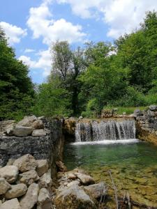 a waterfall next to a pool of water at Guesthouse Pavličić in Drežnik Grad