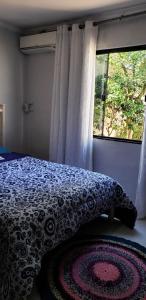 a bedroom with a bed with a pillow and a window at Casa verde in Campo Grande