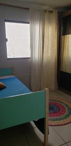 a bedroom with a bed and a window and a rug at Casa verde in Campo Grande
