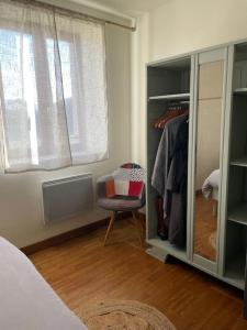 a bedroom with a closet with a chair and a window at Charmante maison à la campagne in Maisoncelles