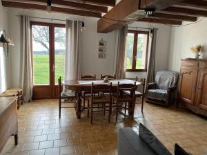 a living room with a dining room table and chairs at Charmante maison à la campagne in Maisoncelles +3 photos