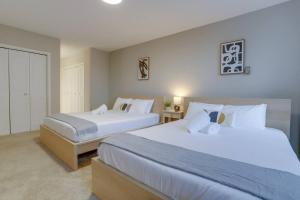 2 bedden in een hotelkamer met witte lakens bij Modern condo at Crystal City in Arlington