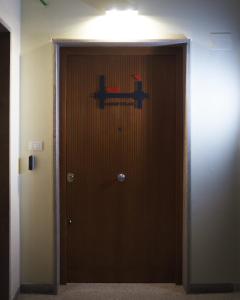 een deur met een bord erop in een kamer bij Hostelò - Luxury Hostel in Palermo