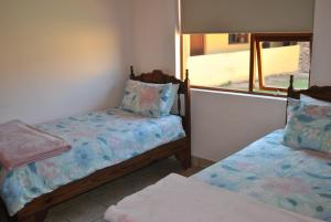 a small room with two beds and a window at Sunflower Cottage in Herbertsdale