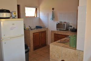 eine Küche mit Kühlschrank und Spüle in der Unterkunft Sunflower Cottage in Herbertsdale