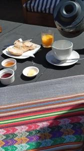 una mesa con platos de comida y un vaso de zumo de naranja en Hotel Casa Puccllana, en Constitución