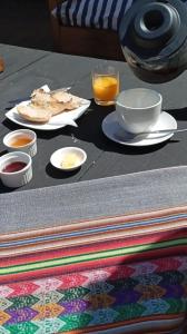 a table with plates of food and a glass of orange juice at Hotel Casa Puccllana in Constitución