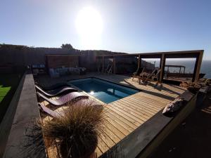 a backyard with a pool and a deck with chairs at Hotel Casa Puccllana in Constitución