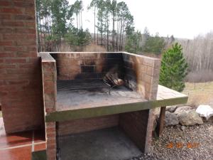 a brick oven with a fire inside of it at Cabañas & Suites "No es Fácil" in Villa Yacanto