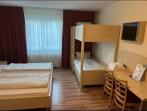 a small room with two bunk beds and a table at Autohof Hotel Salzbergen in Salzbergen