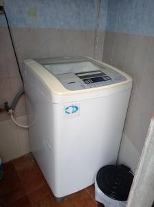 uma máquina de lavar roupa na casa de banho com um caixote do lixo em Apartamento en Vilcabamba em Vilcabamba