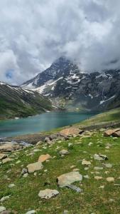 a mountain with a lake in the middle of a field at Srinagar hotels and houseboats in Srinagar