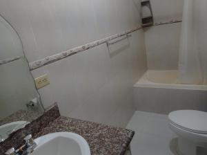 uma casa de banho branca com um WC e um lavatório em Apartamento en Vilcabamba em Vilcabamba