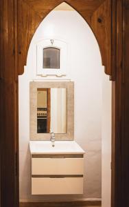 ein Bad mit einem Waschbecken und einem Spiegel in der Unterkunft The Mogador's Oasis in Akermoud