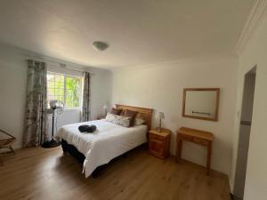 Un dormitorio con una cama grande y una ventana. en Stay@51 Botha, en Oudtshoorn