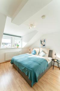 - une chambre avec un grand lit et une couverture bleue dans l'établissement Deluxe Flat, PS4, Parken, Netflix, Zentral, à Bendorf