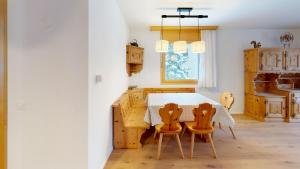 eine Küche mit einem Holztisch und zwei Stühlen in der Unterkunft Dalia E12 in Celerina + 11 Fotos