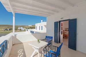 a balcony with blue chairs and a table and a view at Filina's Studio in Maltezana