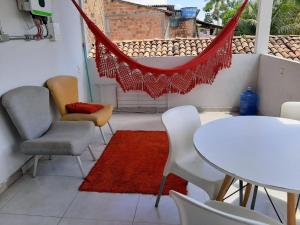 Un balcón con sillas, una mesa y una hamaca. en Casa no Centro (Orla de Marabá) en Marabá