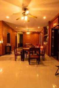 een eetkamer met een tafel en een plafondventilator bij เวลาและนาที Wella&Natee in Chiang Khan