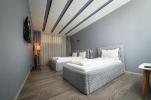 Pokój z dwoma łóżkami i telewizorem w obiekcie Hotel Gloria KS w Prisztinie