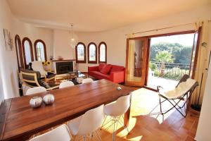 uma sala de estar com uma grande mesa de madeira e cadeiras em Villa Ensueño em Calonge