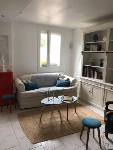 ein Wohnzimmer mit einem Sofa und einem Tisch in der Unterkunft Appartement en duplex avec parking et jardinet in Bourges