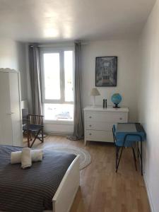 Schlafzimmer mit einem Bett, einem Schreibtisch und einem Fenster in der Unterkunft Appartement en duplex avec parking et jardinet in Bourges
