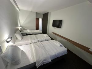 a hotel room with two beds and a flat screen tv at Hotel Pljevlja in Pljevlja