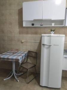 a kitchen with a table and a chair and a refrigerator at Casa Em Olaria, Nova Friburgo, Rua Manoel Lourenço Sobrinho 63 Fundos in Nova Friburgo