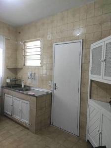 een keuken met een witte deur en een wastafel bij Casa Em Olaria, Nova Friburgo, Rua Manoel Lourenço Sobrinho 63 Fundos in Nova Friburgo