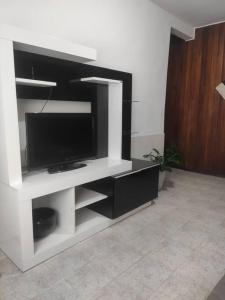 un centro de entretenimiento blanco con TV de pantalla plana en Casa Em Olaria, Nova Friburgo, Rua Manoel Lourenço Sobrinho 63 Fundos en Nova Friburgo