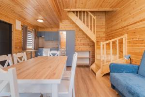 a kitchen and dining room with a table and a blue couch at Domek 7 osobowy piętrowy in Stegna +14 photos