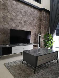 uma sala de estar com uma televisão e uma mesa de centro em Summer Escapes em Johor Bahru