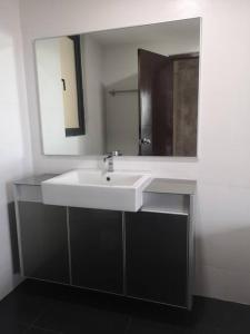 uma casa de banho com um lavatório branco e um espelho. em Summer Escapes em Johor Bahru