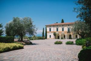 a large house with a brick driveway at Hotel San Lorenzo in Pozzolengo