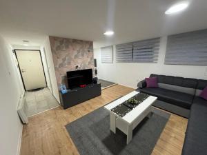 Una sala de estar con un sofá y una mesa de café. en MG Sa, en Sarajevo