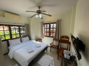 um quarto com uma cama e uma ventoinha de tecto em เวลาและนาที Wella&Natee em Chiang Khan