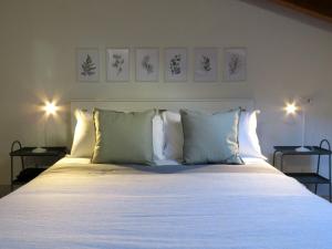 una camera da letto con un grande letto con lenzuola e cuscini bianchi di Campanile Apartment a Pieve di Cento