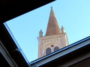 una finestra con vista su una torre dell'orologio. di Campanile Apartment a Pieve di Cento