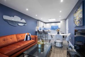 uma sala de estar com um sofá e uma mesa em Elliot Oliver - Exquisite Two Bedroom Apartment With Garden, Parking & EV Charger em Cheltenham