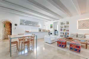 a dining room and living room with a table and chairs at Villa Del Capitolo Con Trullo By Raro Villas in Carovigno