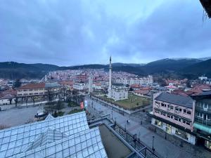 Blick auf eine Stadt mit Gebäuden und einem Uhrturm in der Unterkunft Hotel Pljevlja in Pljevlja