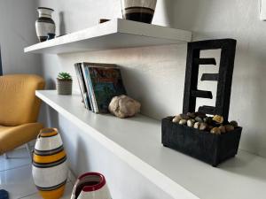 une étagère blanche avec une boîte de rochers sur elle dans l'établissement Casa no Centro (Orla de Marabá), à Marabá