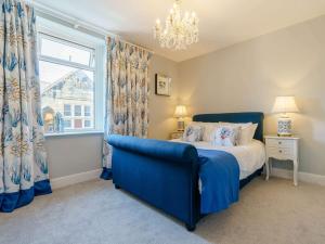 a bedroom with a blue bed and a window at 3 Bed in Amble 83995 in Amble